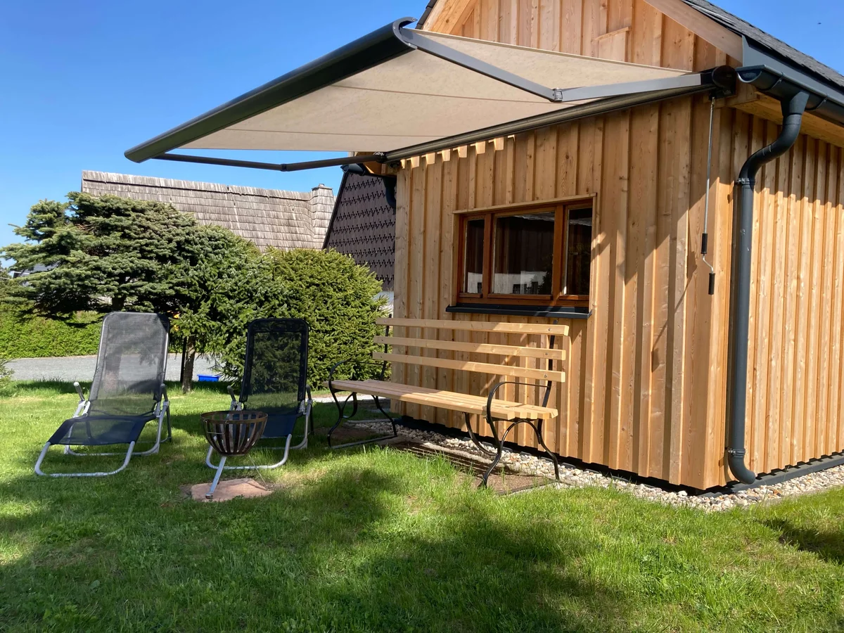 Außenansicht der Unterkunft mit Balkon und Garten