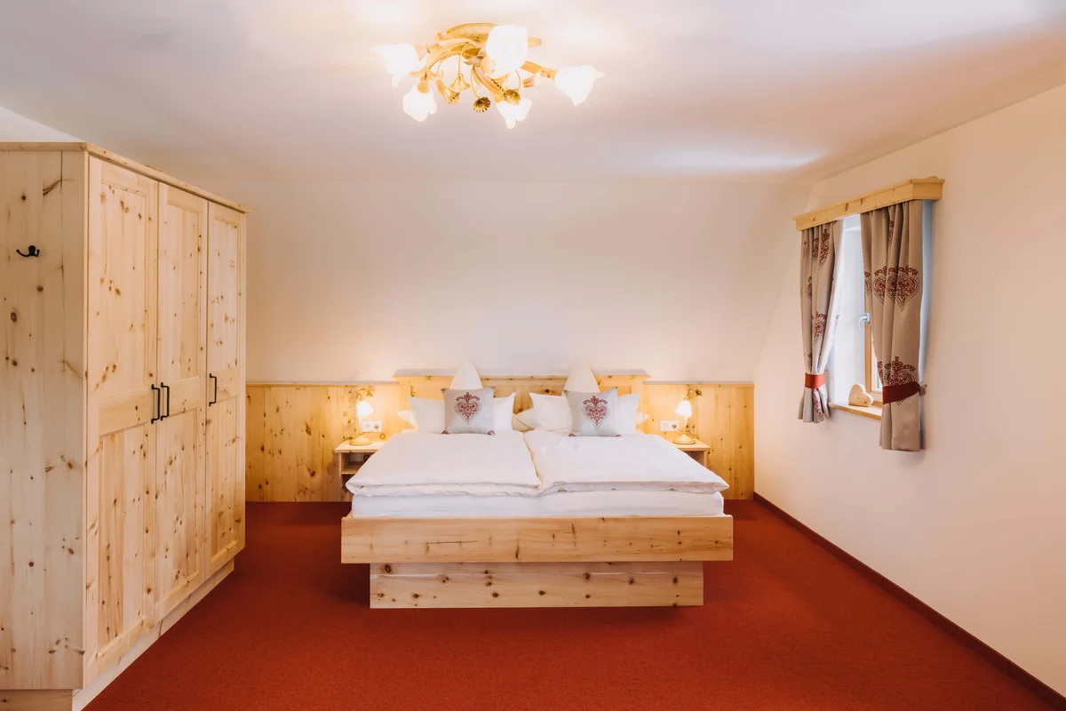 Schlafzimmer mit Doppelbett und Holzmöbeln